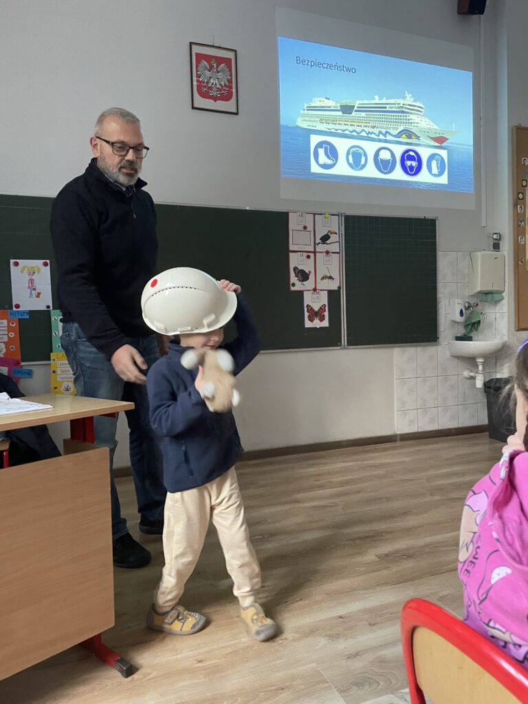 Children wearing safety helmets during a shipbuilding presentation